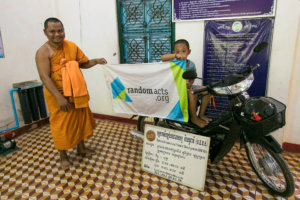 One of the monks and a local child pose with the new motorbike