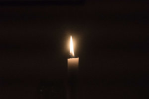 lit candle with a black background