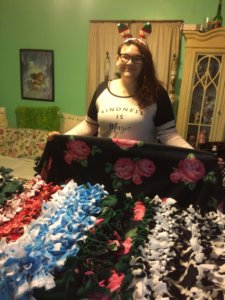 Dreana posing with the twelve blankets made for Mercy House residents.