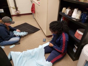 students craftung fleece snuffle mats for shelter pets