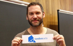 Jason Manns holding up a sign that says Random Acts