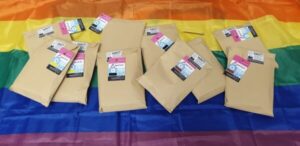 Packages of chest binders on a rainbow flag