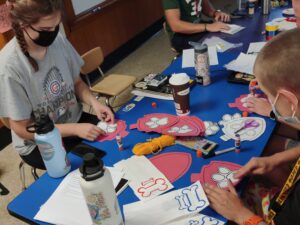 Staff at an after school program create craft items for birthday boxes going to children who missed birthday parties during the pandemic