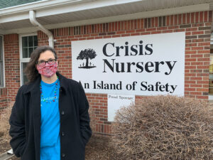 Lisa smiling with Crisis Nursery sign in background